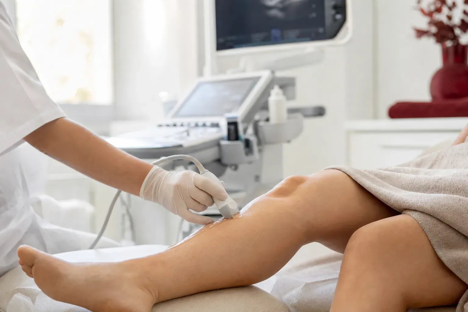 A doctor performs an ultrasound scan of the leg veins